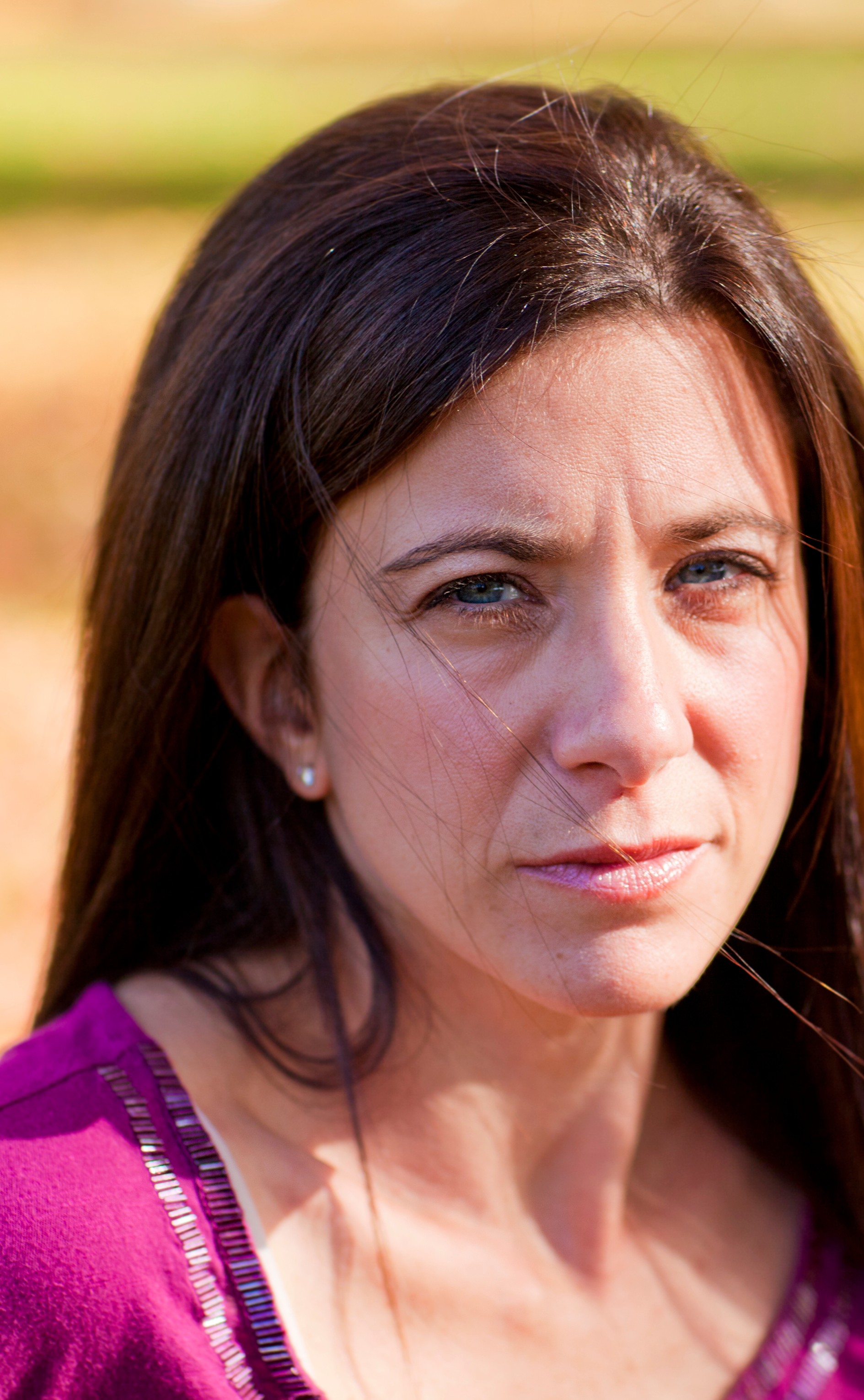 White woman, looking serious, in rural setting